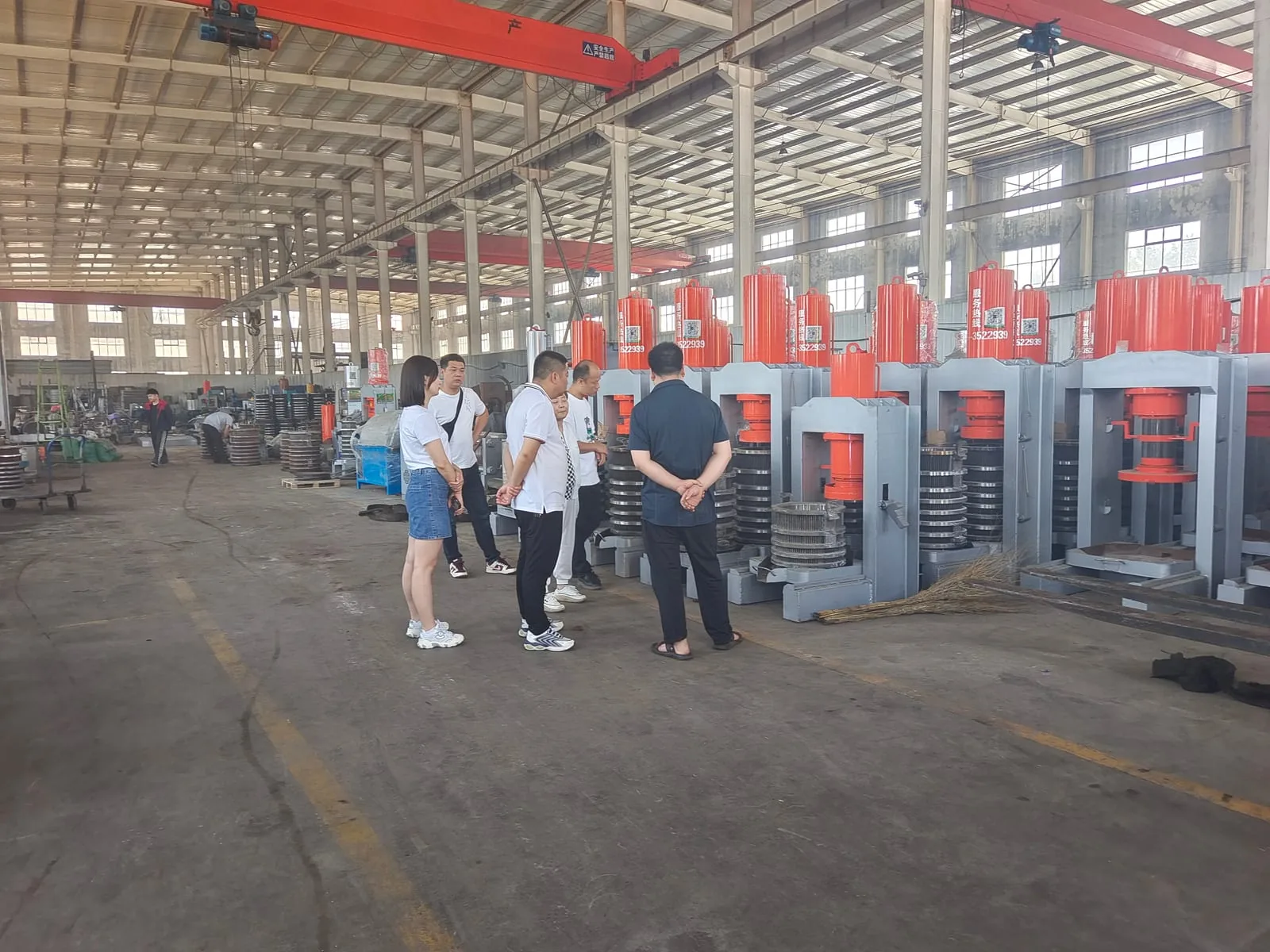 Overseas buyers inspecting finished hydraulic presses during a factory visit
